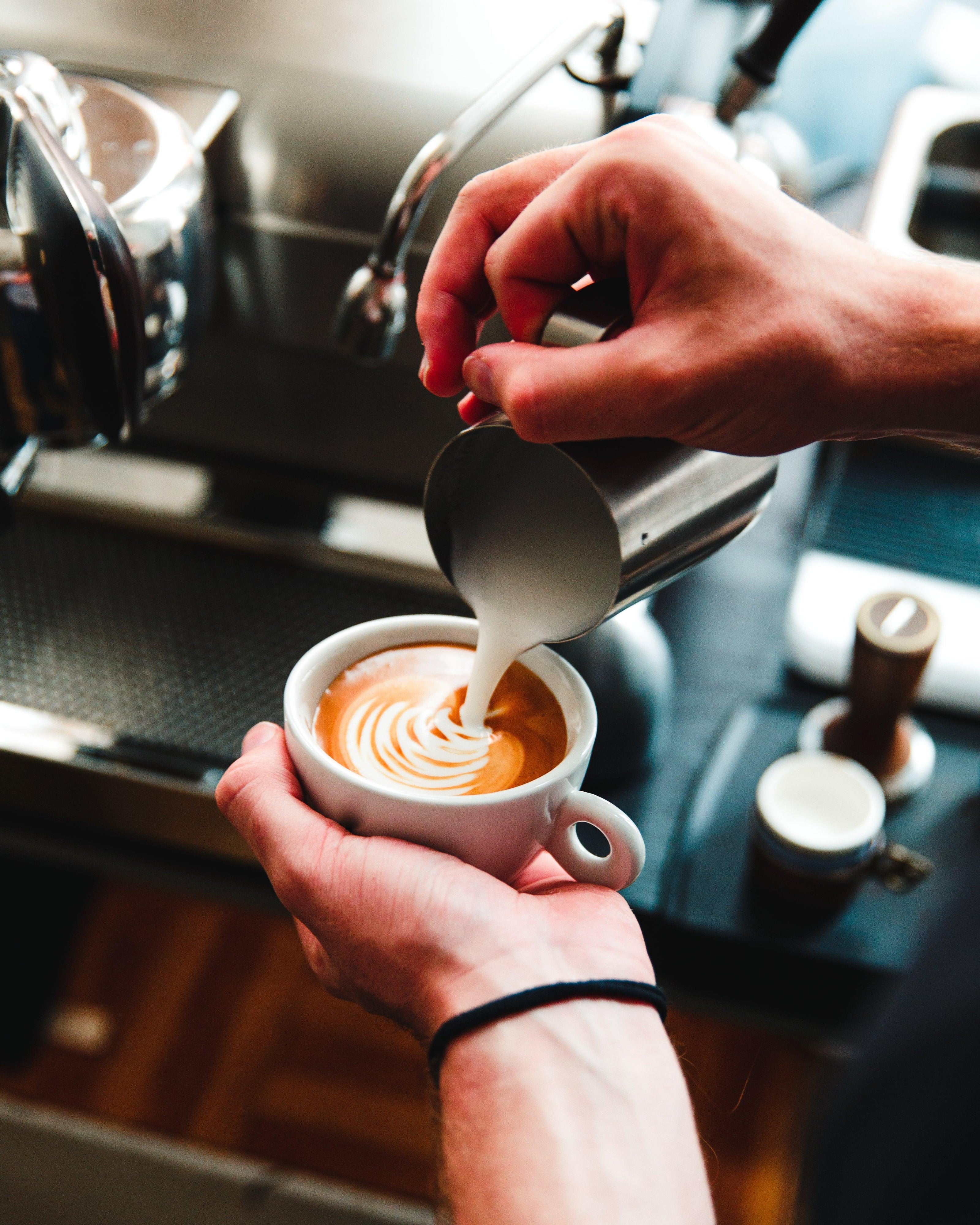 barista-pours-steamed-milk-on-espresso - LG's coffee